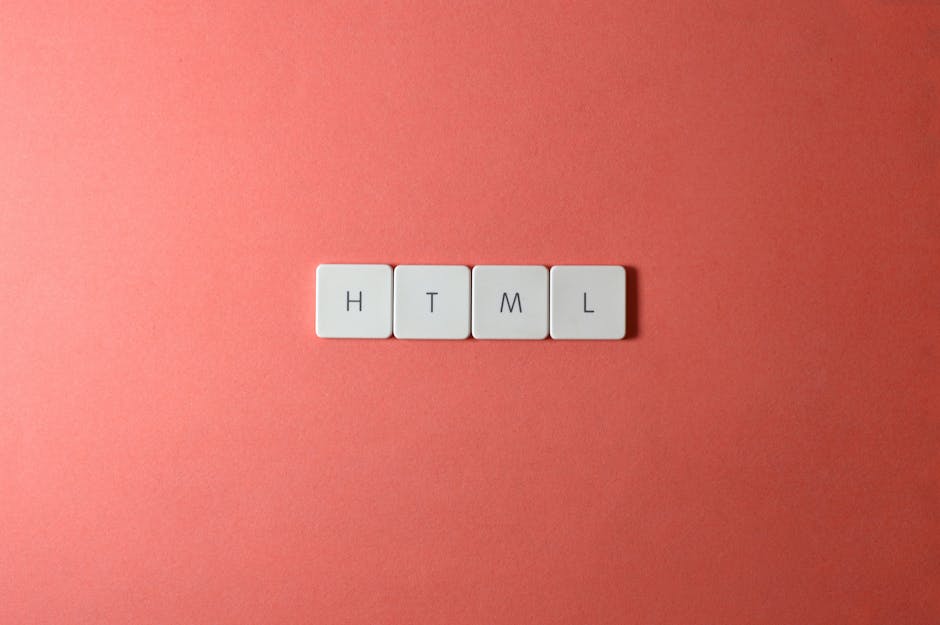 A close-up of four white tiles with black letters spelling 'H', 'T', 'M', and 'L' arranged on a dark gray surface, representing the basic elements of surface cleaning and digital sanitisation concepts